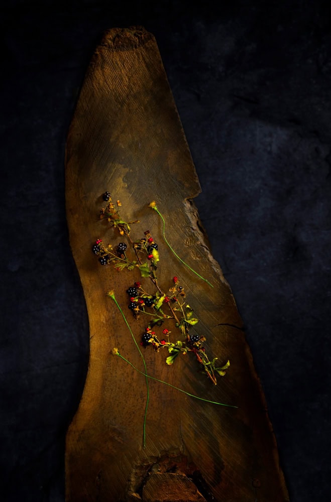 A still life where a lit surface sits against deep, deliberate shadow