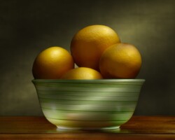 Fresh lemons in a green ceramic bowl on a wooden surface, with a dark background. Lemons in Green Bowl Still Life Light Painting by Bobby Izquierdo