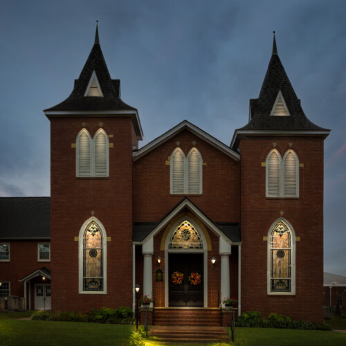 This is a photograph of the United First Methodist Church in downtown Pittsboro, NC. It was taken on Oct. 10, 2021, and converted to nighttime using post-processing. The photographer removed the usually visible powerlines and other distracting elements. Pittsboro nightscape fine art photograph by Bobby Izquierdo, limited edition